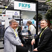 Prof. Dr. Hans-Christian Reuss vom FKFS (links) und Dr. Wolfgang Fischer von e-mobil BW im intensiven Gespräch, während sie innovative Mobilitätslösungen diskutieren.