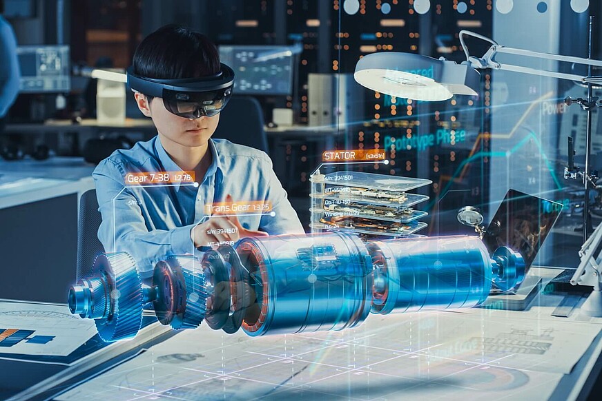 Ingenieur mit AR-Headset betrachtet den Hologramm-Prototypen eines Elektromotors.