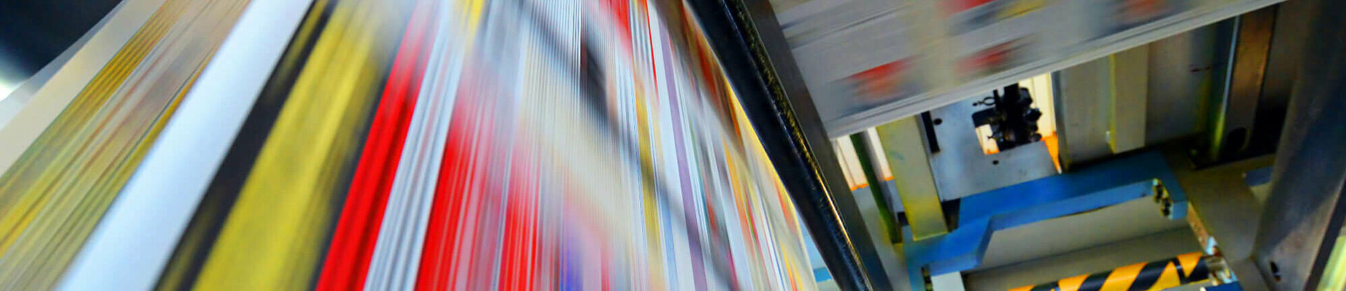 Druckpapier einer Zeitung läuft über eine Walze.