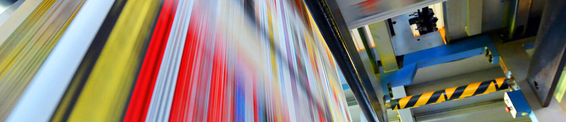 Druckpapier einer Zeitung läuft über eine Walze.