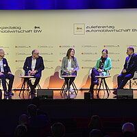 Fünf Personen sitzen auf dem Podium zu einer Diskussionsrunde. 