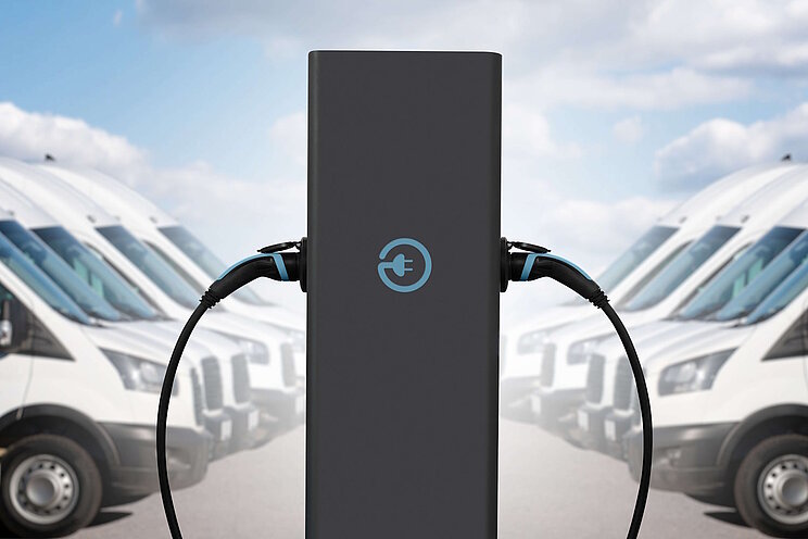 Ladesäule mit 2 Ladepunkten und E-Transportern rechts und links aufgereiht