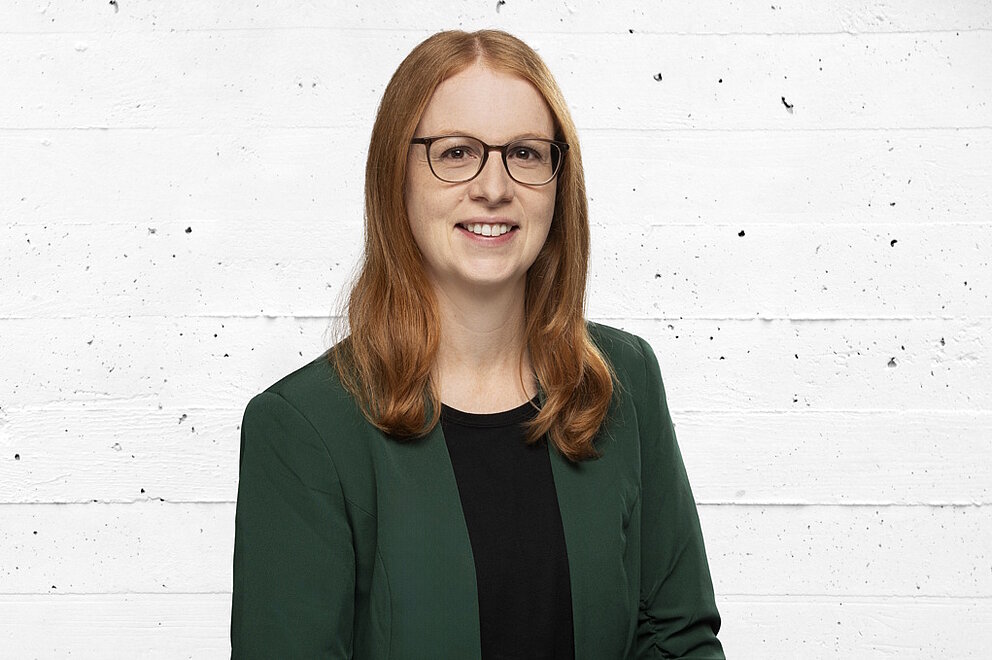 Porträt von Julia Bulling vor einer grauen Betonwand
