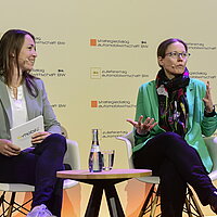 Saskia Schüttke (e-mobil BW) und Prof. Dr.-Ing. Ina Schaefer (Karlsruher Institut für Technologie) sitzen auf dem Podium beim Zulieferertag Automobilwirtschaft BW 2023.