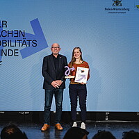 Verkehrsminister Hermann übergibt Jana Zieger den Preis bei der Landesauszeichnung "Wir machen Mobilitätswende"