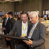 Gunnar Mey und Luiz Cesio Alves stehen im Gespräch nebeneinander