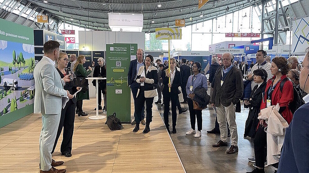Fachbesucher stehen am Baden-Württemberg-Messestand der hy-fcell 2024