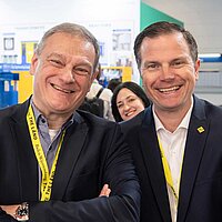 Franz Loogen (e-mobil BW) und Gunnar Mey (Baden-Württemberg International) grinsen in die Kamera.