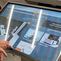 Die Teilnehmenden testen den Innovationsradar Kfz-Gewerbe an einem Touch-Screen.