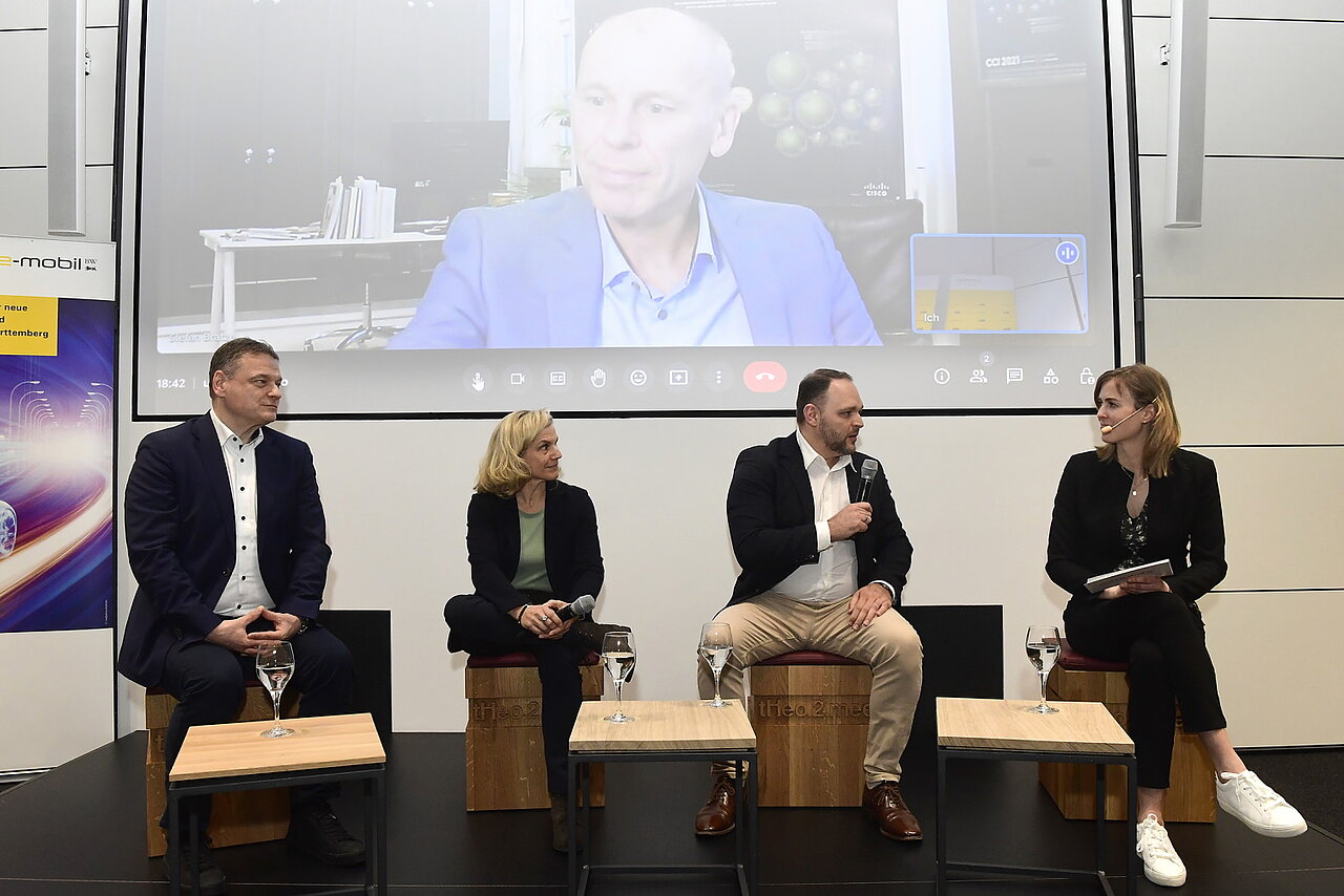 Die Speaker der Podiumsdiskussion: Franz Loogen, Geschäftsführer e-mobil BW, Cathrin Lind, Vice President Operations bei EnBW mobility+ AG & Co. KG, Damir Dulovic, Gründer und CEO von Swarm Logistics, Theresa Abb, e-mobil BW und im Hintergrund Prof. Dr. Stefan Bratzel, Gründer und Direktor des Center of Automotive Management.