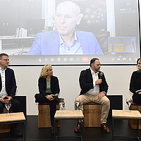 Die Speaker der Podiumsdiskussion: Franz Loogen, Geschäftsführer e-mobil BW, Cathrin Lind, Vice President Operations bei EnBW mobility+ AG & Co. KG, Damir Dulovic, Gründer und CEO von Swarm Logistics, Theresa Abb, e-mobil BW und im Hintergrund Prof. Dr. Stefan Bratzel, Gründer und Direktor des Center of Automotive Management.