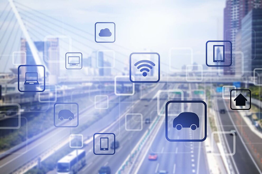 Das Bild zeigt im Hintergrund eine Autobahn, darüber befinden sich Symbole für Digitalisierung, smarte Fahrzeuge und Infrastruktur.