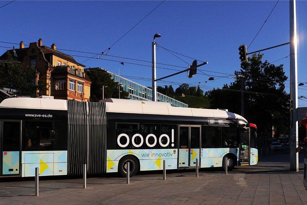 Ein Gelenkbus fährt in Esslingen unter einer Oberleitung, über die er während der Fahrt seinen Batteriespeicher lädt