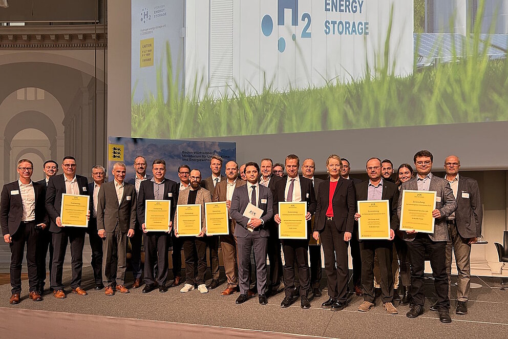 Repräsentanten der ELY-Projekte stehen mit den Verträgen in der Hand gemeinsam auf der Bühne bei der Förderübergabe in Stuttgart. 