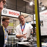 Zwei Männer unterhalten sich über ein Industriegerät.