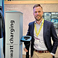 Walter Holderried von e-mobil BW hält einen Stecker zum Megawatt-Laden für Nutzfahrzeuge