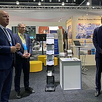 Das Foto zeigt Philippe Vangeel (AVERE, Secretary General), Franz Loogen (e-mobil BW) und Espen Hauge (President of the World Electric Vehicle Association (WEVA) and of AVERE) auf dem deutschen Gemeinschaftsstand auf der EVS35 in Oslo.