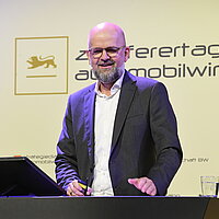 Andreas Rade auf der Bühne des Zulieferertags Automobilwirtschaft BW 2023. 