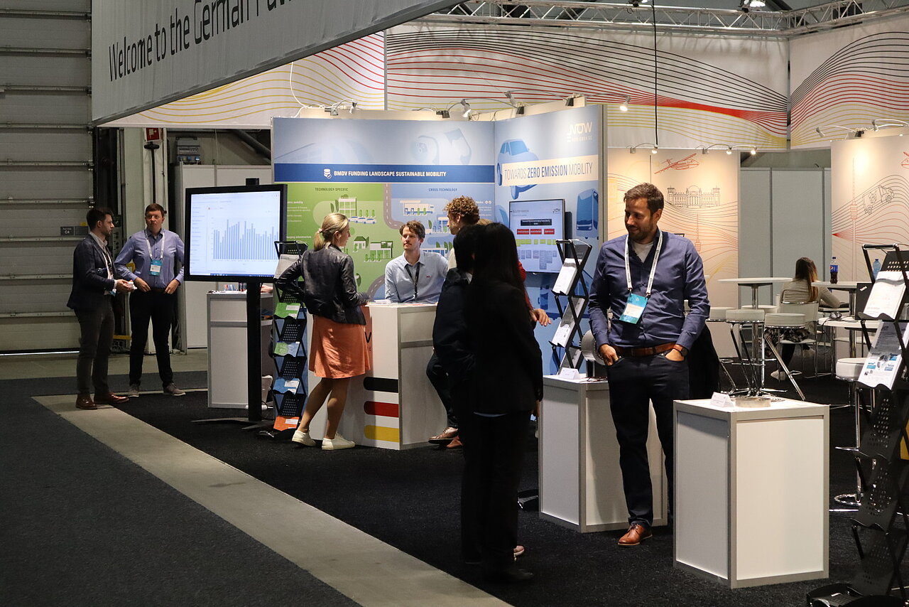 Visitors talking with exhibitors at the German pavilion at the EVS35 in Norway.
