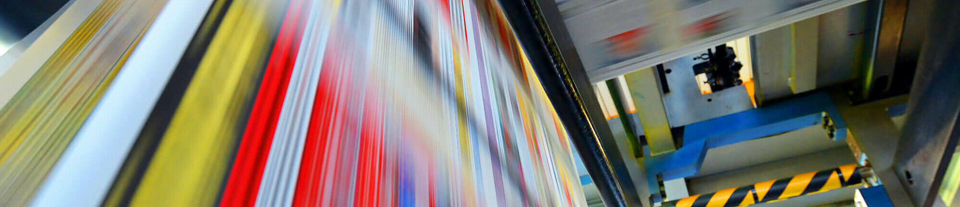 Druckpapier einer Zeitung läuft über eine Walze.