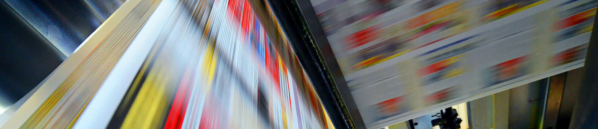 Druckpapier einer Zeitung läuft über eine Walze.