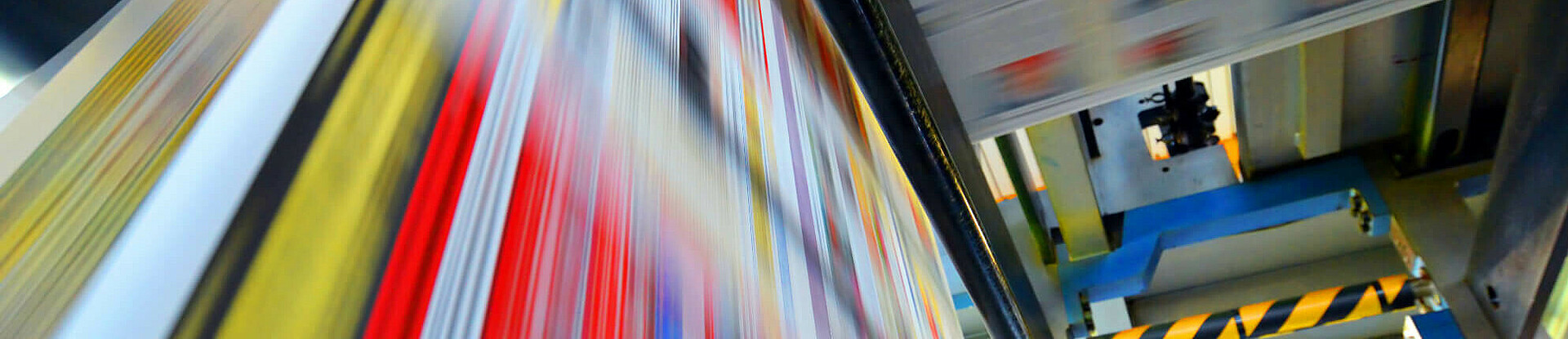 Druckpapier einer Zeitung läuft über eine Walze.