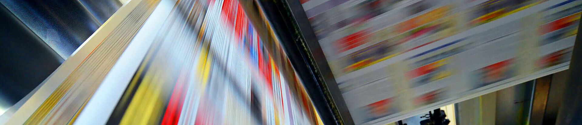 Druckpapier einer Zeitung läuft über eine Walze.