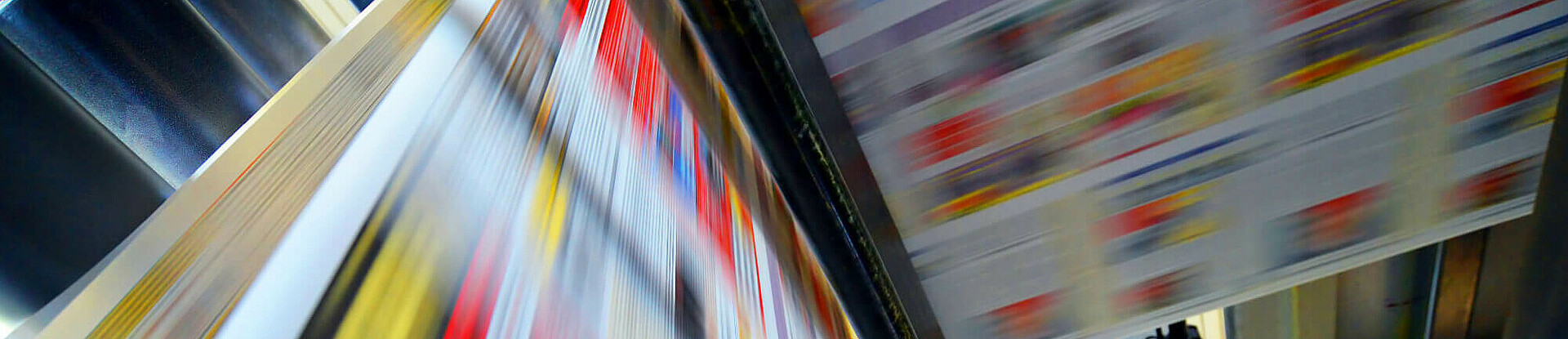 Druckpapier einer Zeitung läuft über eine Walze.