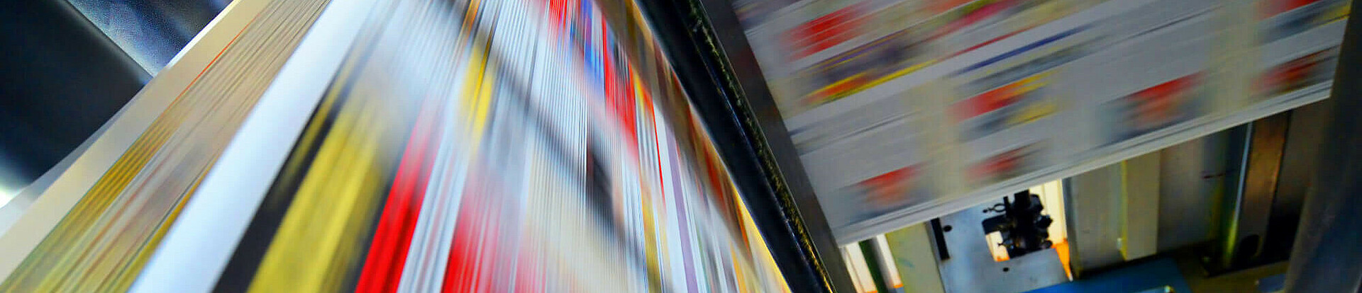 Druckpapier einer Zeitung läuft über eine Walze.