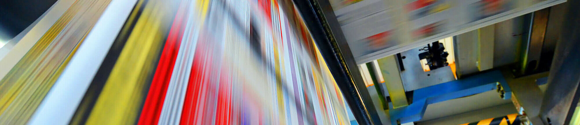 Druckpapier einer Zeitung läuft über eine Walze.