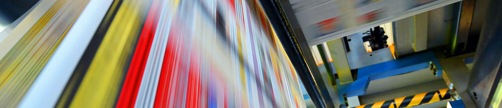 Druckpapier einer Zeitung läuft über eine Walze.