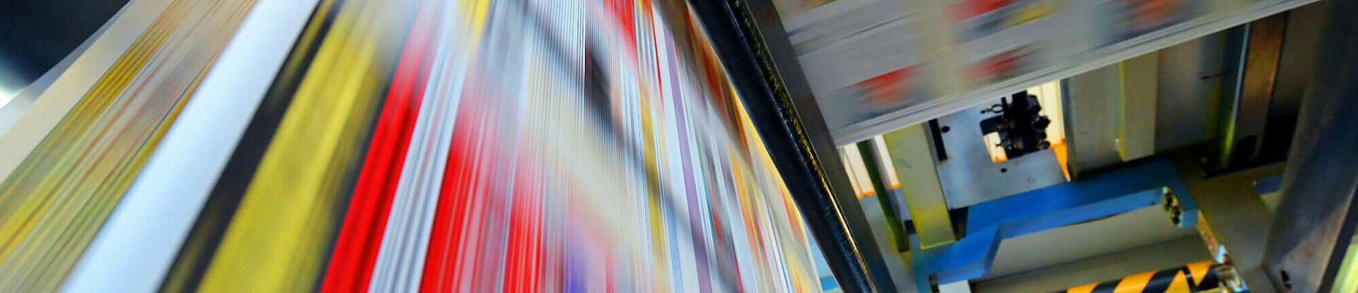 Druckpapier einer Zeitung läuft über eine Walze.