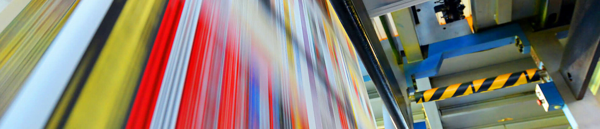 Druckpapier einer Zeitung läuft über eine Walze.