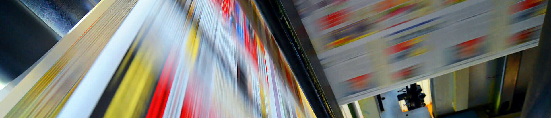 Druckpapier einer Zeitung läuft über eine Walze.