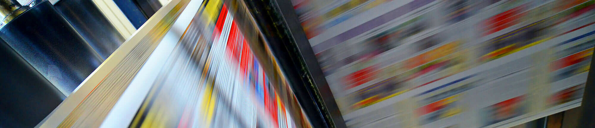 Druckpapier einer Zeitung läuft über eine Walze.