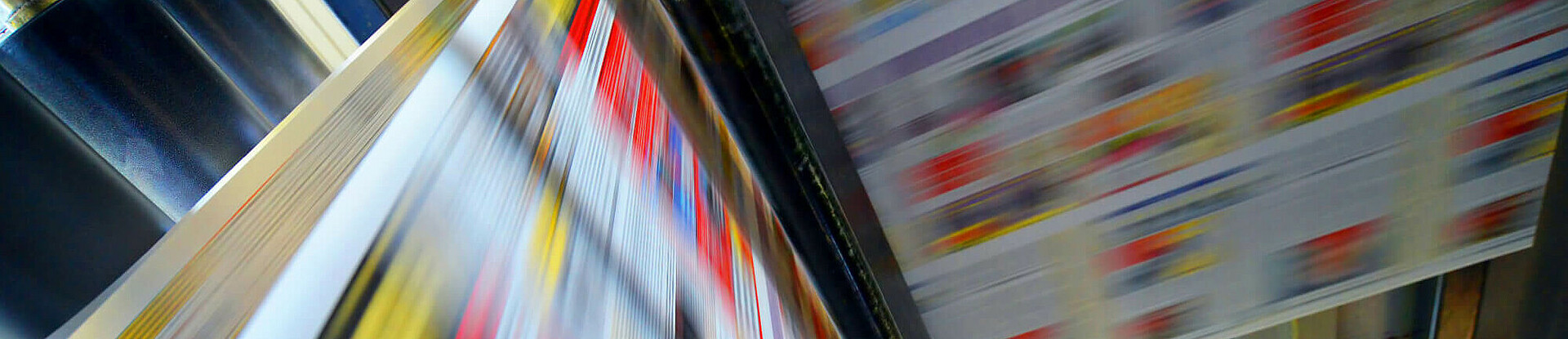 Druckpapier einer Zeitung läuft über eine Walze.