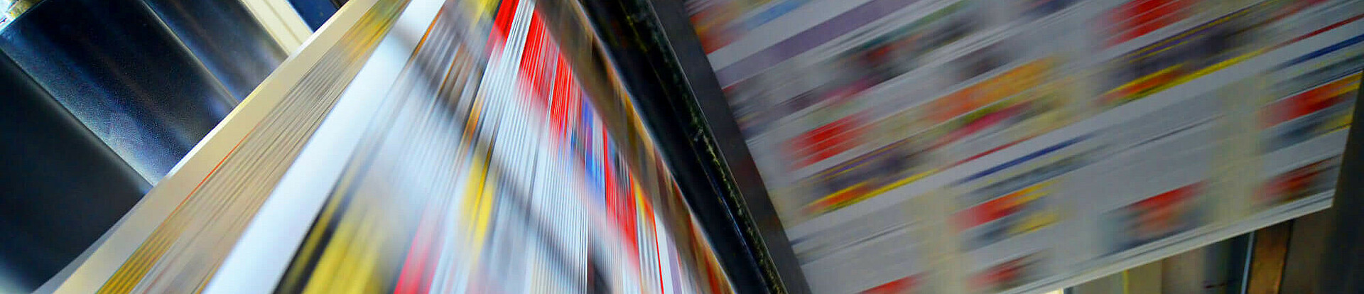 Druckpapier einer Zeitung läuft über eine Walze.