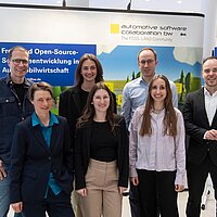 Ein Teil des Teams der e-mobil BW GmbH bei der OpenChain and Friends 2026. Das Team posiert vor einer Messewand.