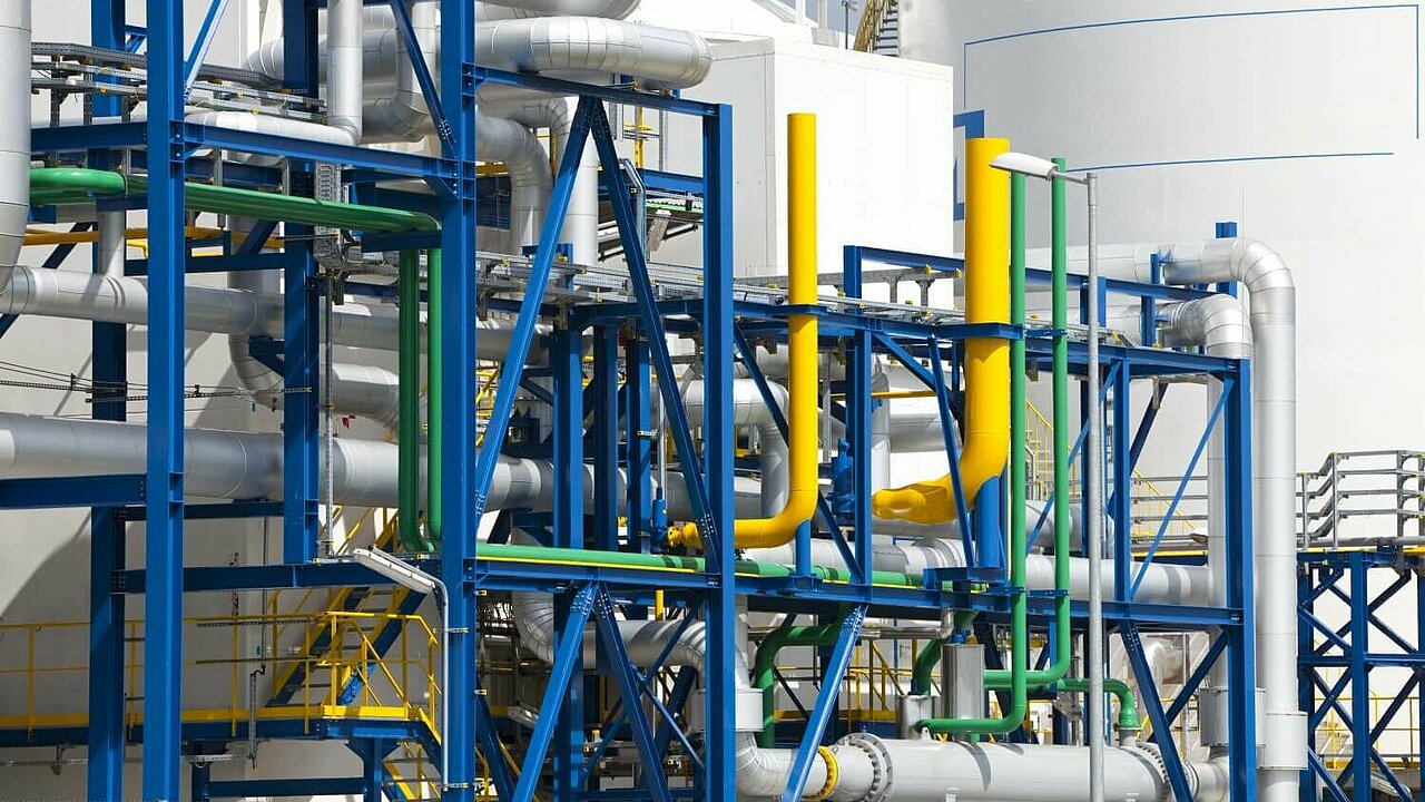 Wasserstoffspeicher im Hintergrund, Leitungen in verschiedenen Farben im Vordergrund
