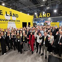 Ein Gruppenbild auf der Hannover Messe 2026 am baden-württembergischen Gemeinschaftsstand. Die Gruppe winkt in die Kamera.