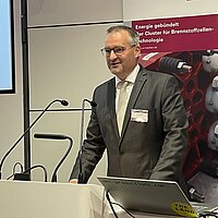 Ulrich Spitzer steht am Rednerpult bei der 10 Jahre Jubiläumsfeier des Clusters Brennstoffzelle BW