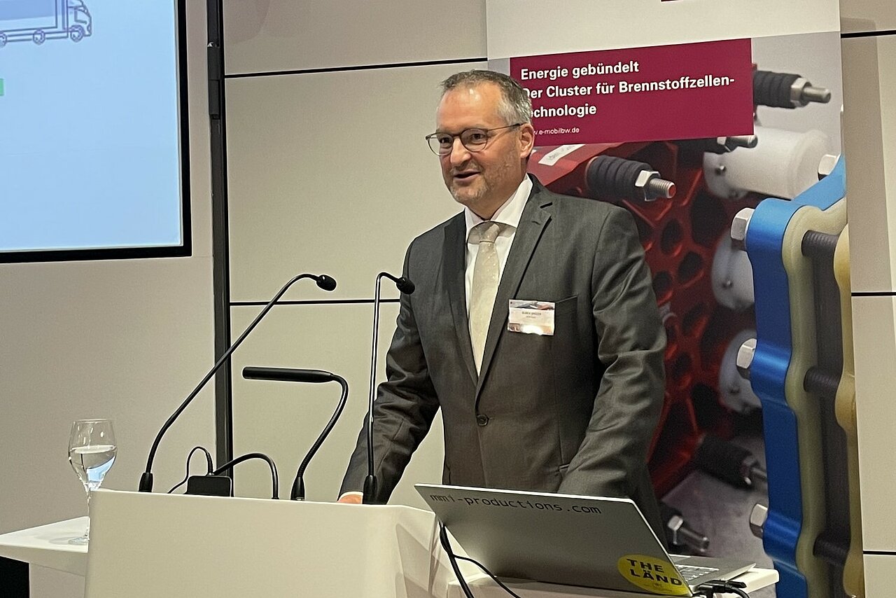Ulrich Spitzer steht am Rednerpult bei der 10 Jahre Jubiläumsfeier des Clusters Brennstoffzelle BW