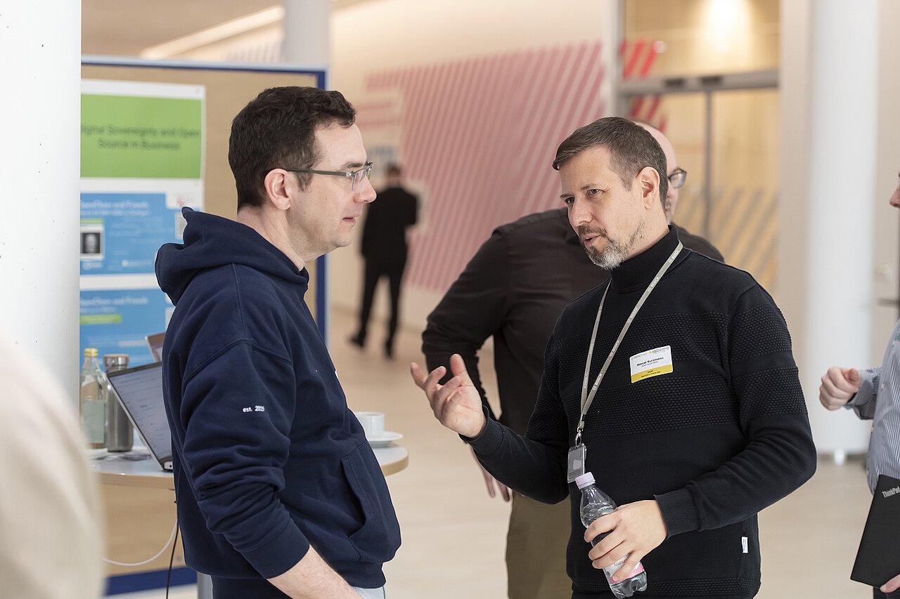 Zwei Teilnehmende bei der OpenChain and Friends Veranstaltung im Gespräch.