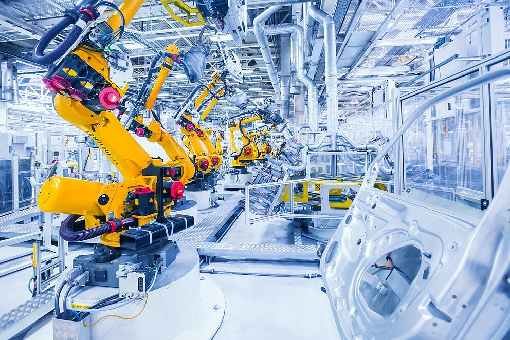 Gelbe Roboterarme in einer Automobilfabrik