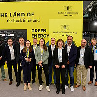 Gruppenfoto von Mitgliedern des Clusters Elektromobilität Süd-West vor Beginn ihres Messe-Rundgangs.