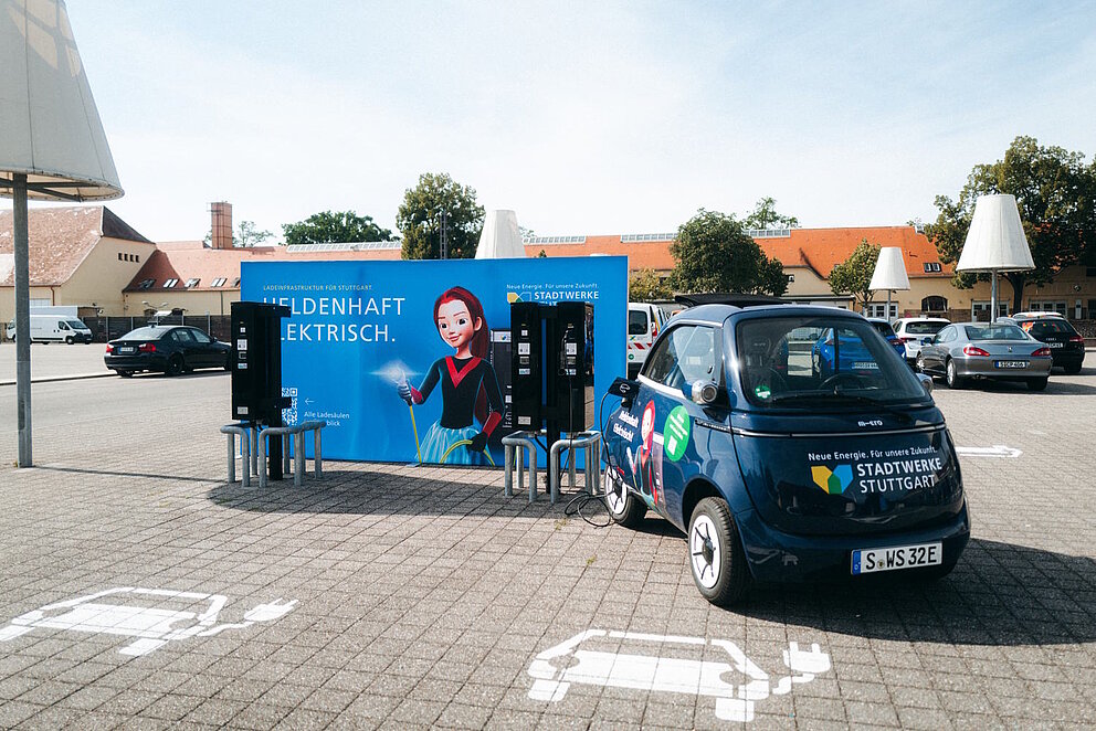 Impressionen vom neuen E-Ladepark am Römerkastell, ein dunkelblaues kleines Elektroauto steht auf dem Parkplatz an der Ladesäule der Stadtwerke Stuttgart.