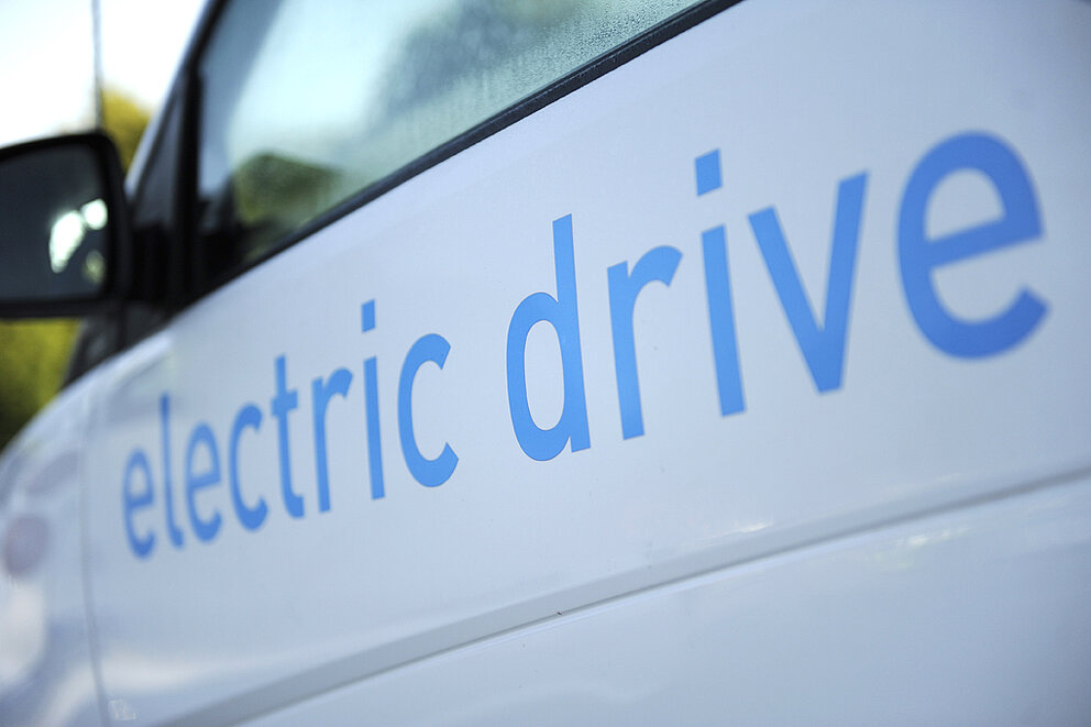 Blauer Schriftzug "electric drive" auf einem weißen E-Auto 