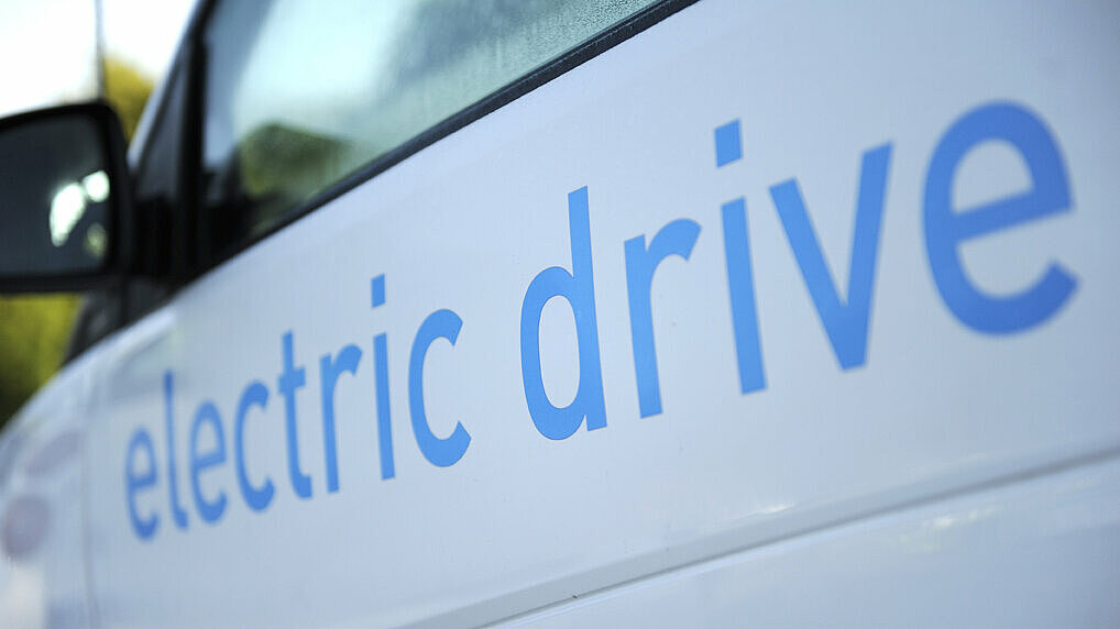 Blauer Schriftzug "electric drive" auf einem weißen E-Auto 