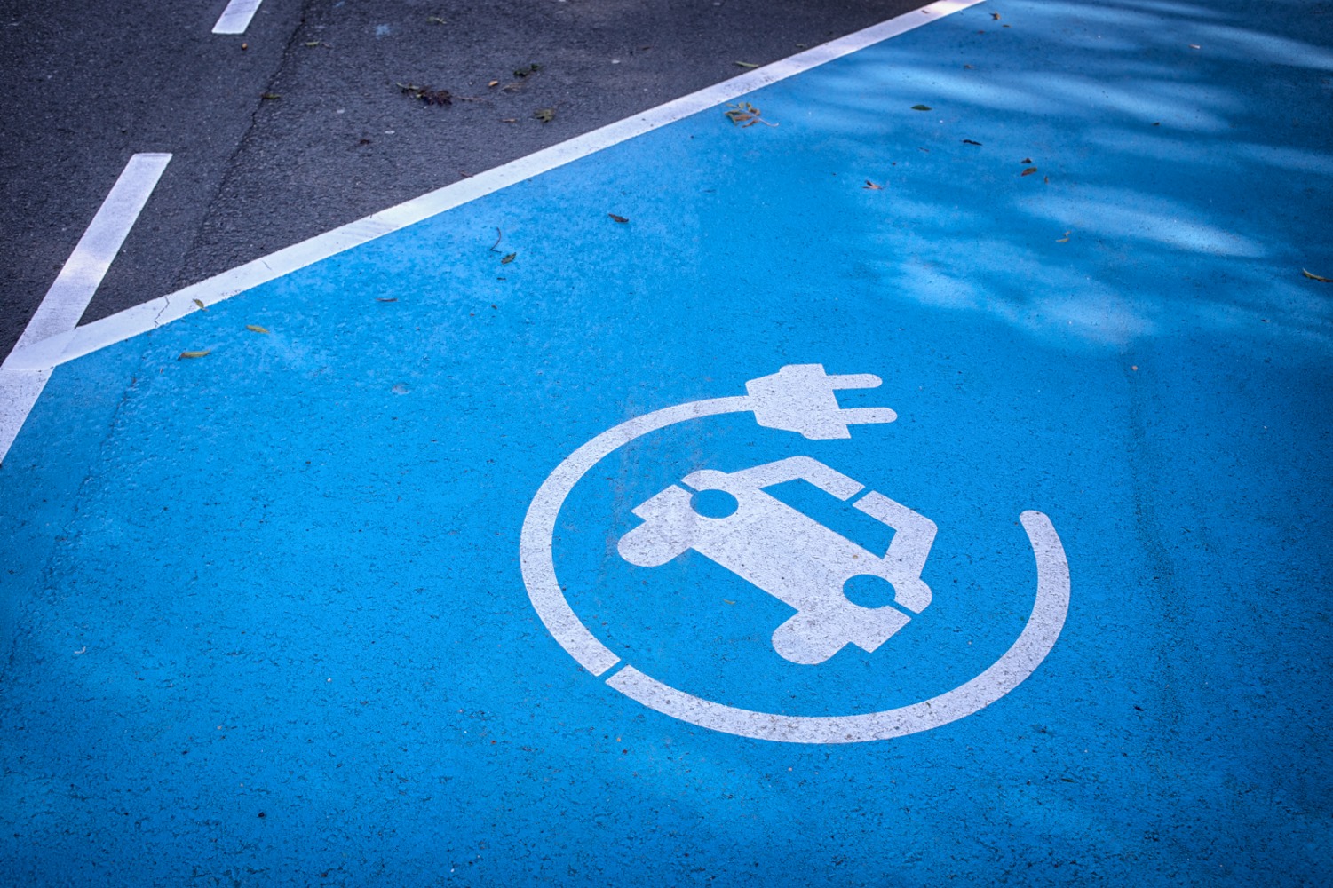 Eine blaue Parkfläche mit einem E-Auto Symbol darauf.