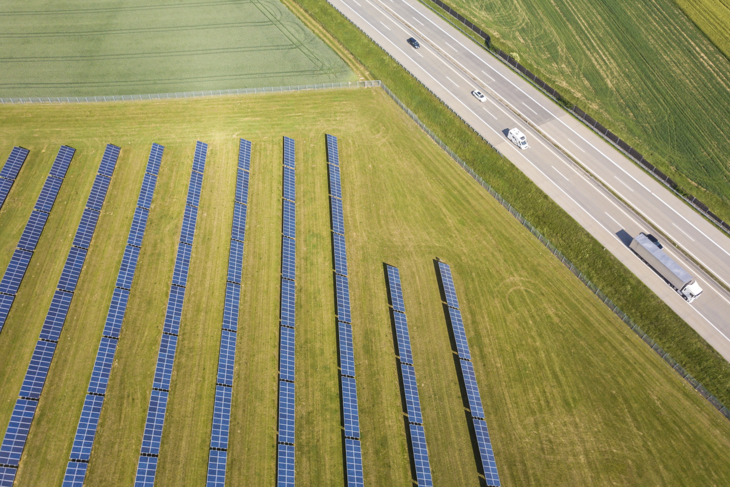 Ein Solarfeld mit einer Straße daneben.